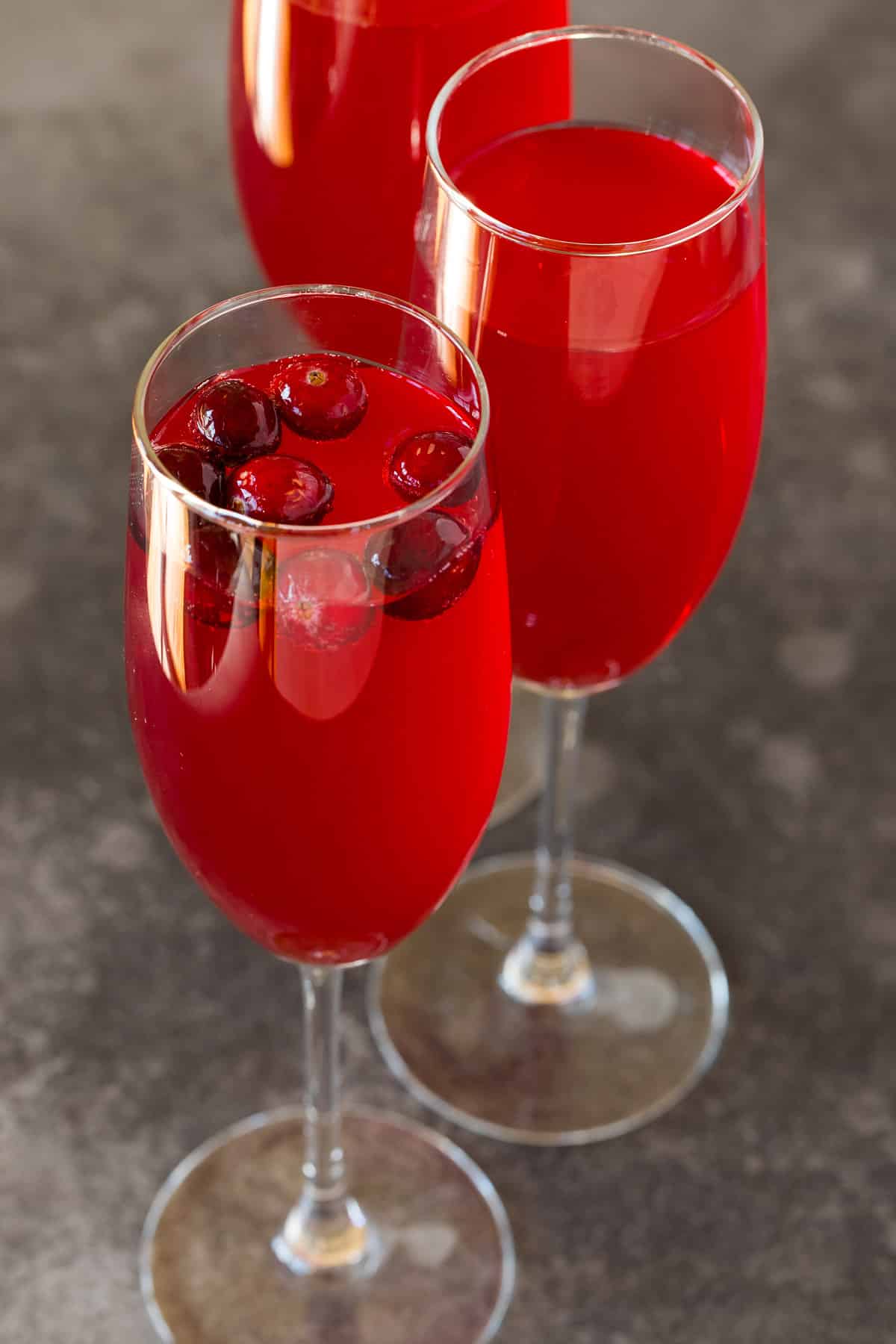 Glasses of champagne cranberry cocktail with fresh cranberries in them.