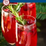 This poinsettia cocktail is a blend of cranberry juice, orange liqueur and champagne, all mixed together and garnished with fresh cranberries and rosemary.