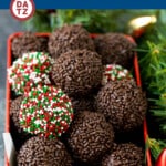 A tin of rum balls with Christmas decorations.