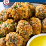 A plate of sausage cheese balls with honey mustard dip.