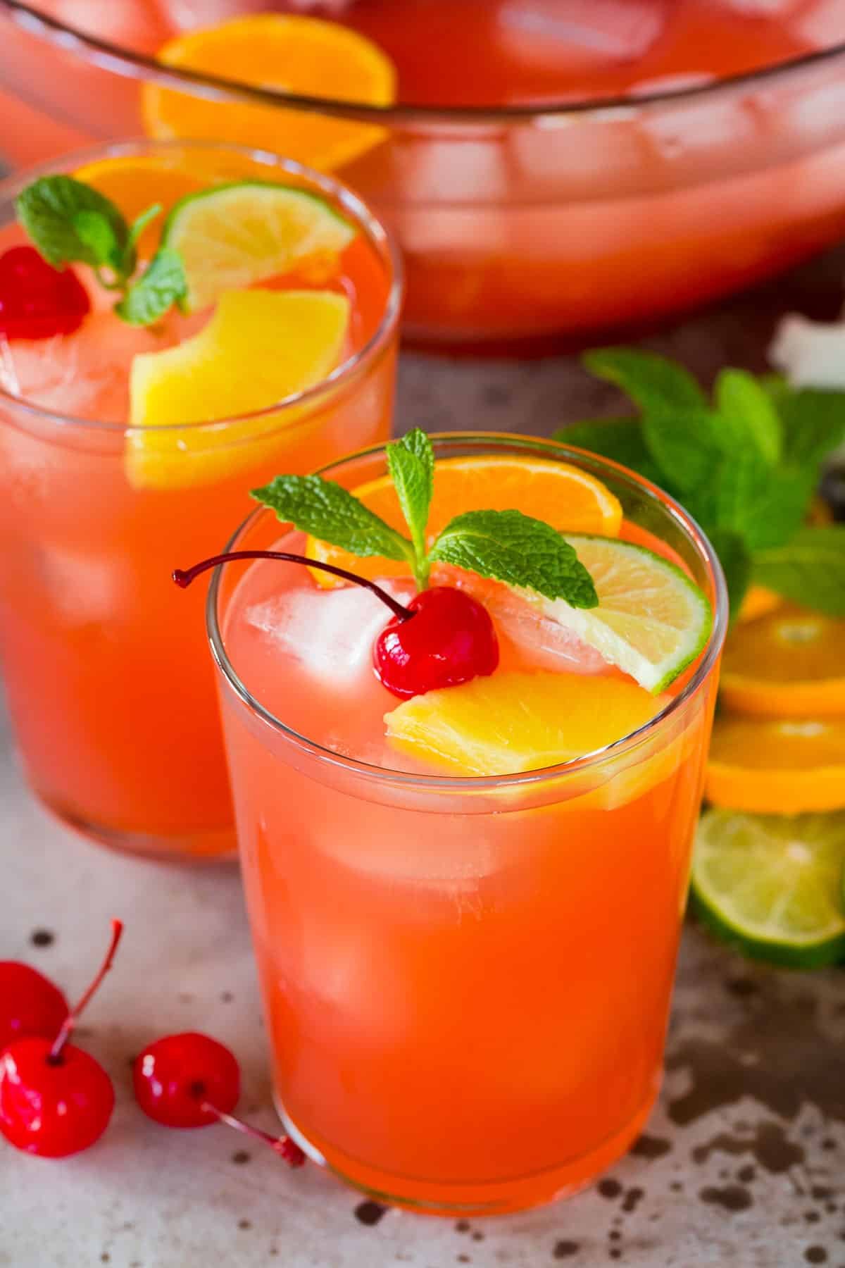 Cups of vodka punch topped with fruit and fresh mint.