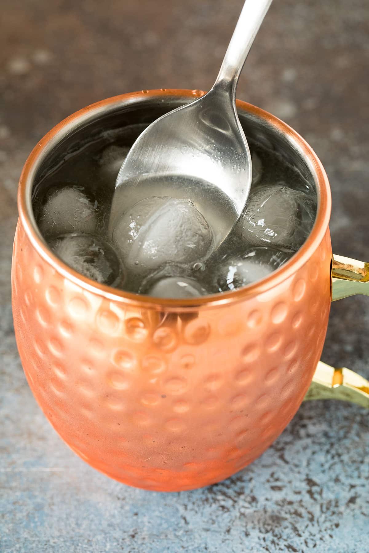 A spoon stirring a mule drink.