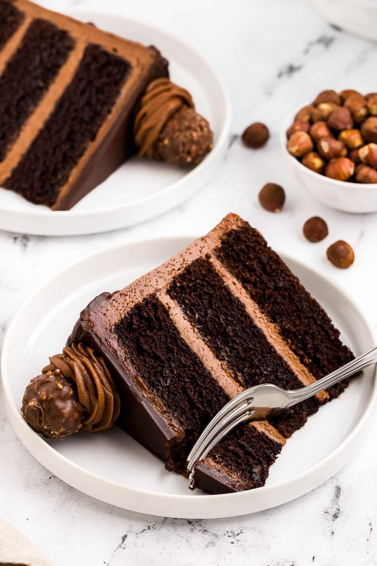 A slice of layered Nutella cake with a fork in it.