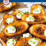 A place of potato skins with bacon, sour cream and green onions on top.