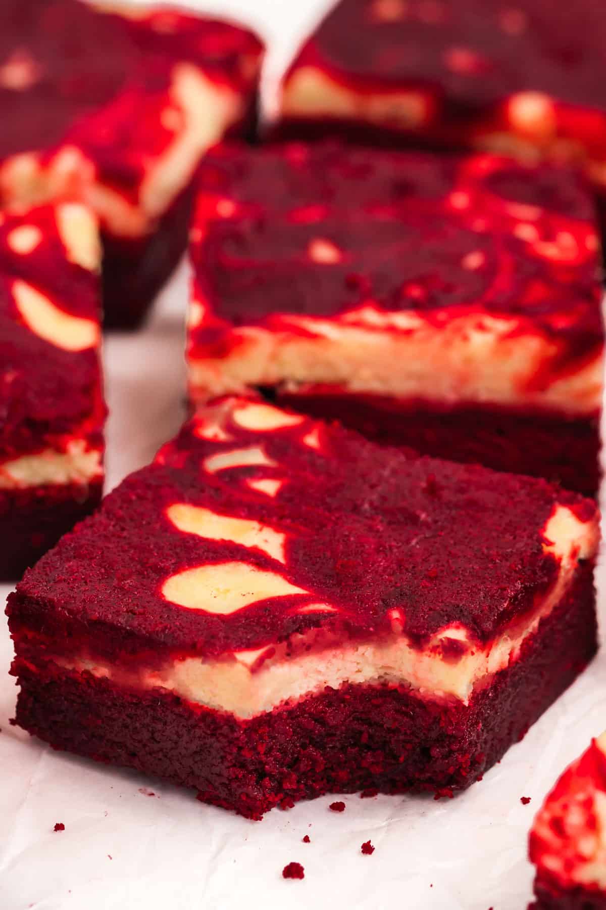 Red velvet brownies with a bite taken out of one of them.