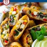 A plate of southwestern egg rolls with avocado ranch sauce.