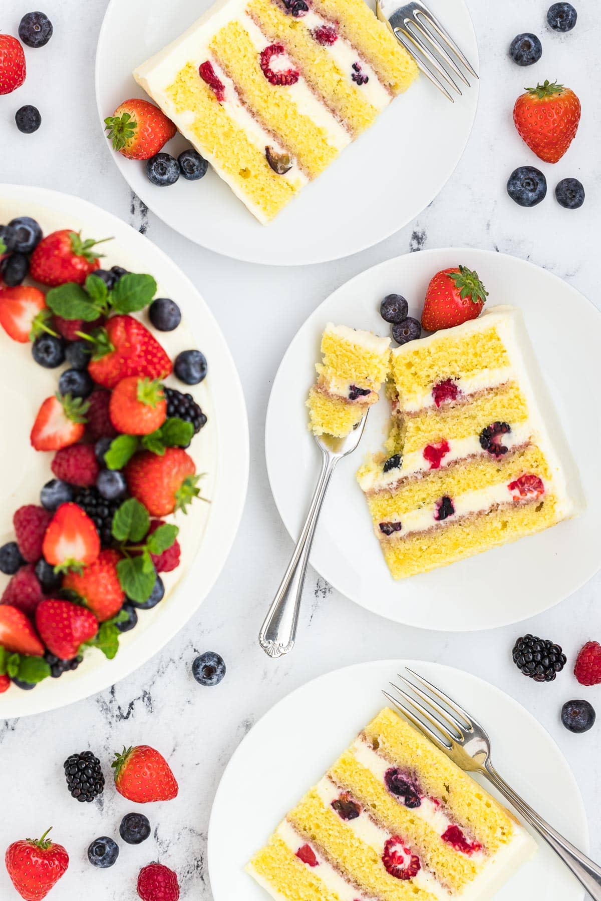 Slices of berry chantilly cake with a fork in one slice.