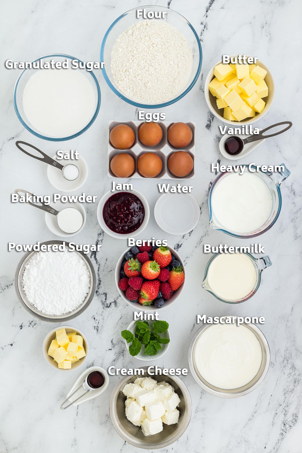 Ingredients including flour, sugar, butter, eggs, berries, jam and cream cheese.