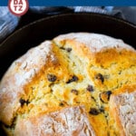 A skillet with a loaf of Irish soda bread with raisins.