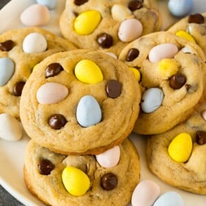 A plate of mini egg cookies topped with chocolate chips and chocolate eggs.