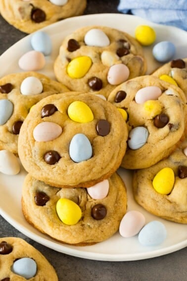 A plate of mini egg cookies topped with chocolate chips and chocolate eggs.