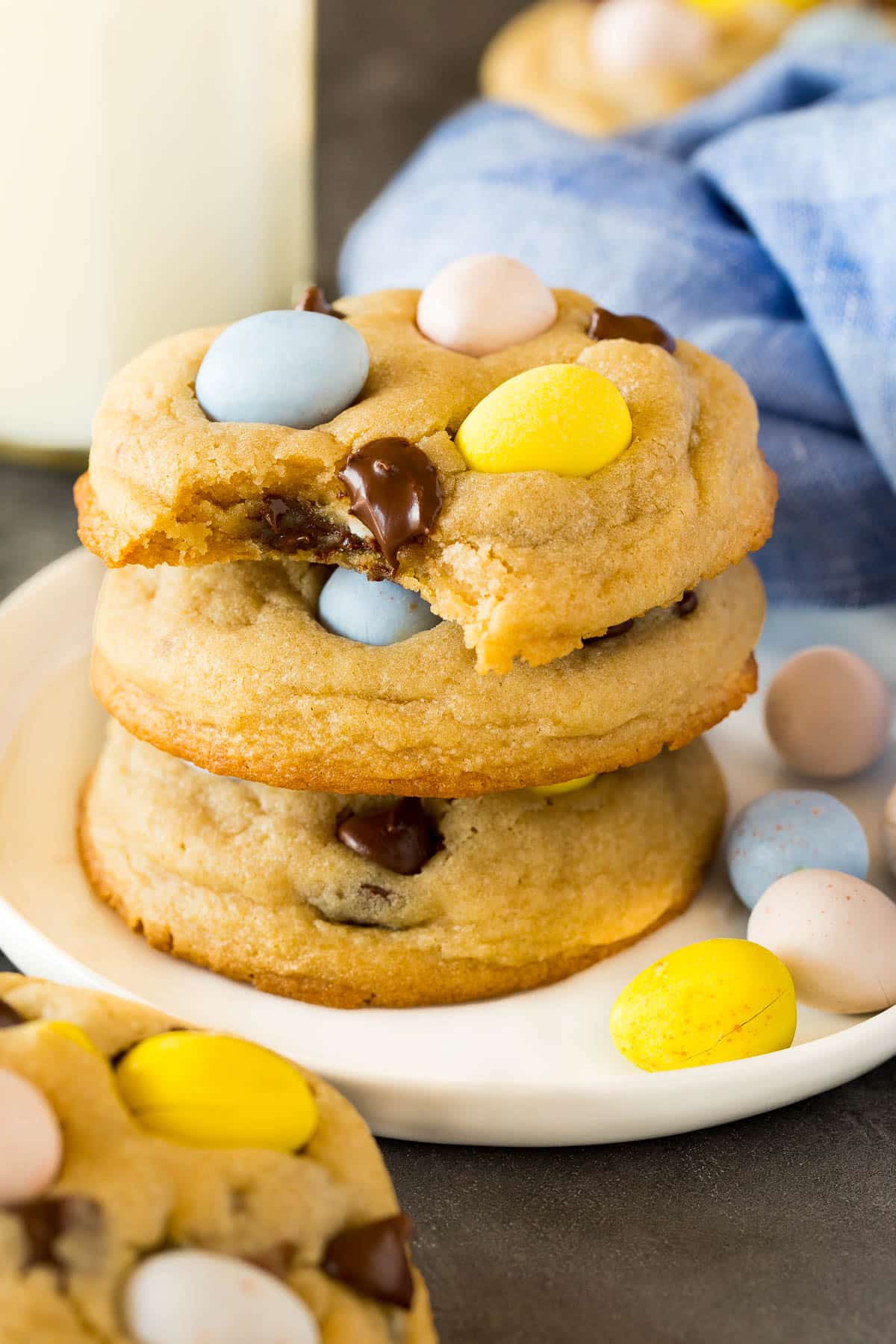 A stack of mini egg cookies with a bite taken out of one.