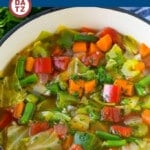 A pot of cabbage soup garnished with fresh parsley.