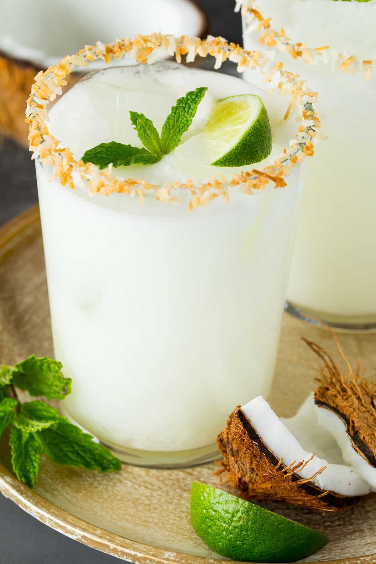 A coconut margarita garnished with lime and mint.