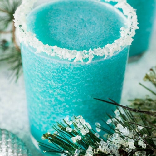 A glass of jack frost cocktail with a coconut crusted rim.