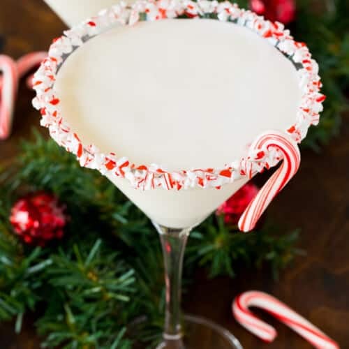 A peppermint martini in a candy cane coated glass.