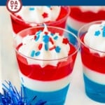 These red white and blue Jello shots are layers of cherry, condensed milk and berry gelatins, all topped with whipped cream and patriotic sprinkles.