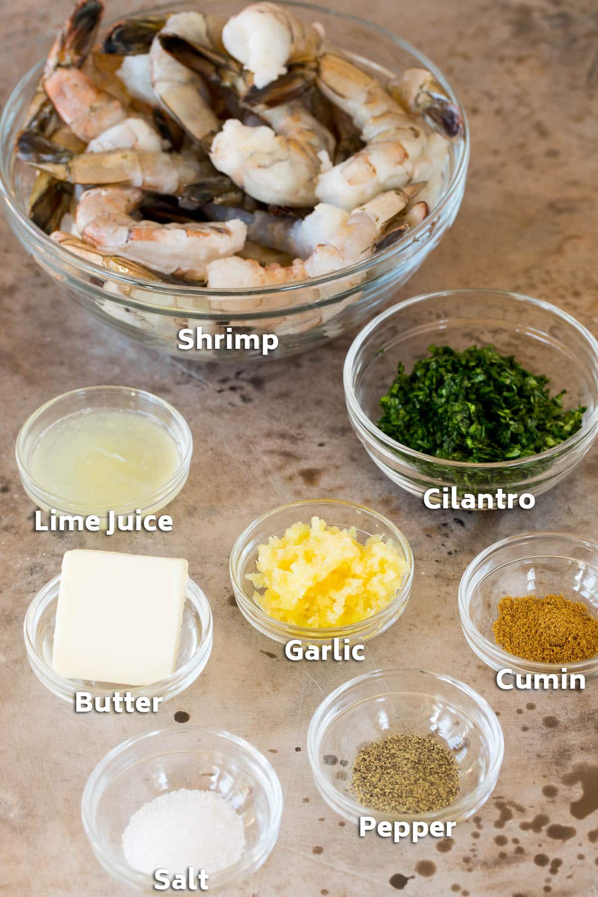 Bowls of ingredients including butter, garlic, shrimp and cumin.
