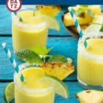 Glasses of pineapple coconut smoothie garnished with pineapple wedges and lime wedges.