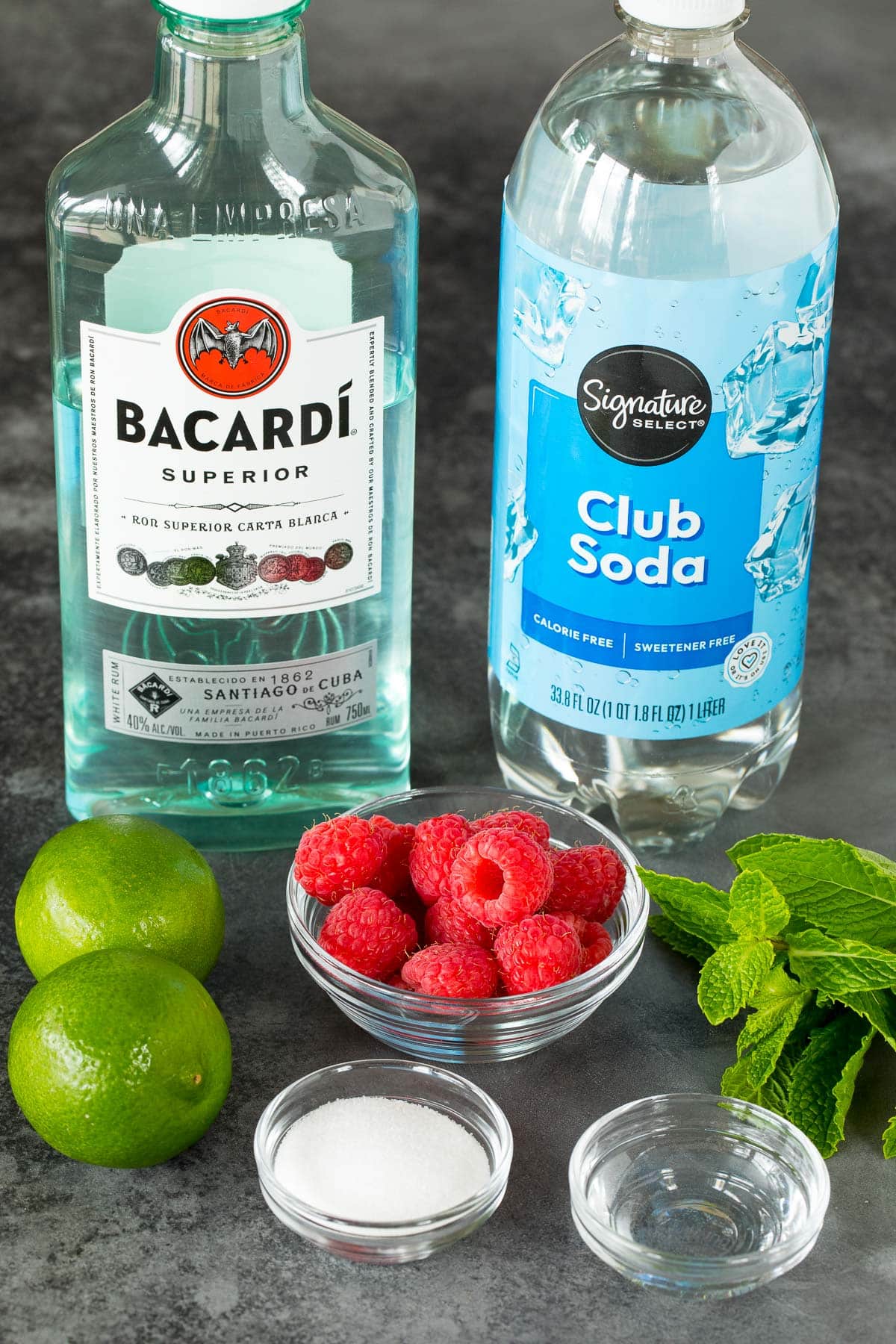 Ingredients including lime, mint, sugar, rum, club soda and berries.