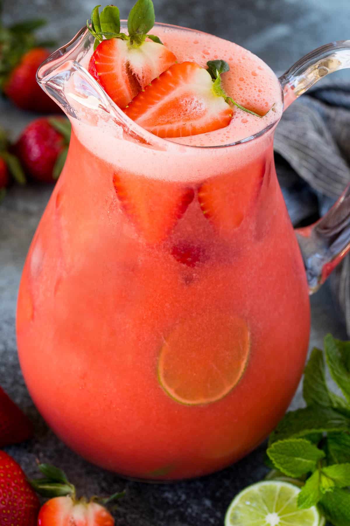 A glass pitcher filled with strawberry agua fresca.