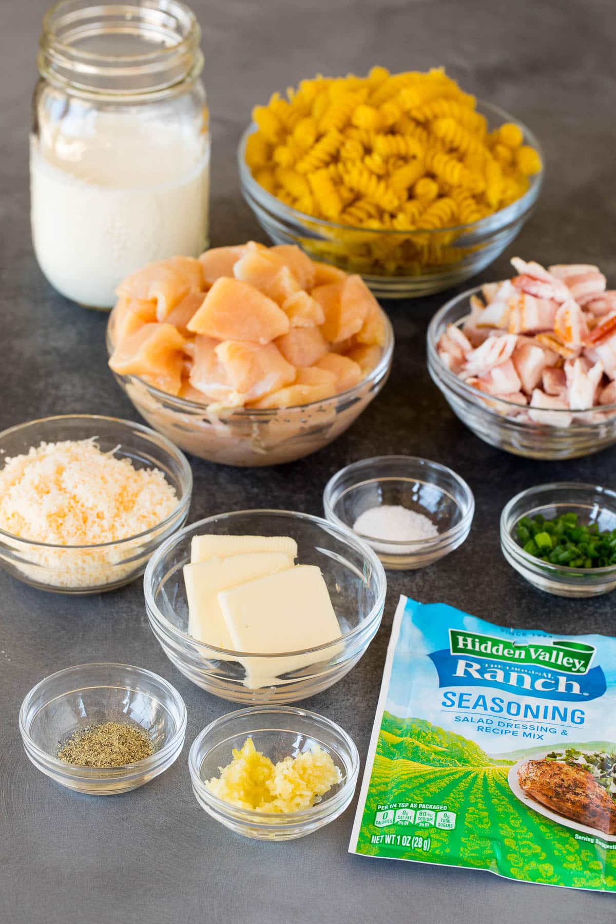 Bowls of ingredients including noodles, butter, herbs, cheese and seasonings.
