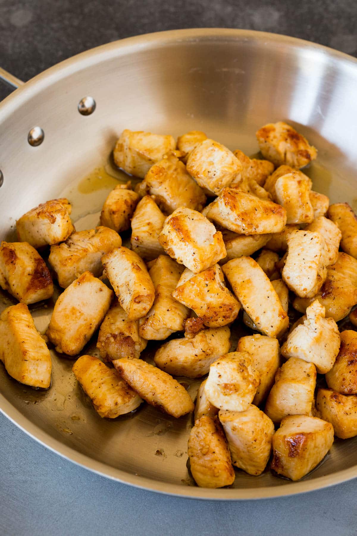 Sauteed chicken pieces in a skillet.