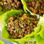 A plate full of beef lettuce wraps garnished with green onions.
