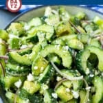 A bowl of cucumber feta salad featuring cucumbers, feta, red onion and avocado.