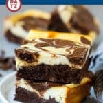 A small plate with two cheesecake brownies on it.