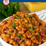 A bowl of cowboy beans with bacon and a tangy sauce.
