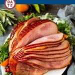 A spiral ham on a plate with garnishes.