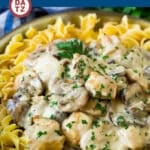 A pan of noodles with creamy chicken stroganoff on top.